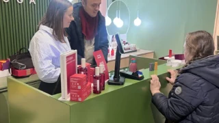 Mokinė prie kosmetikos parduotuvės kasos su pardavėjais